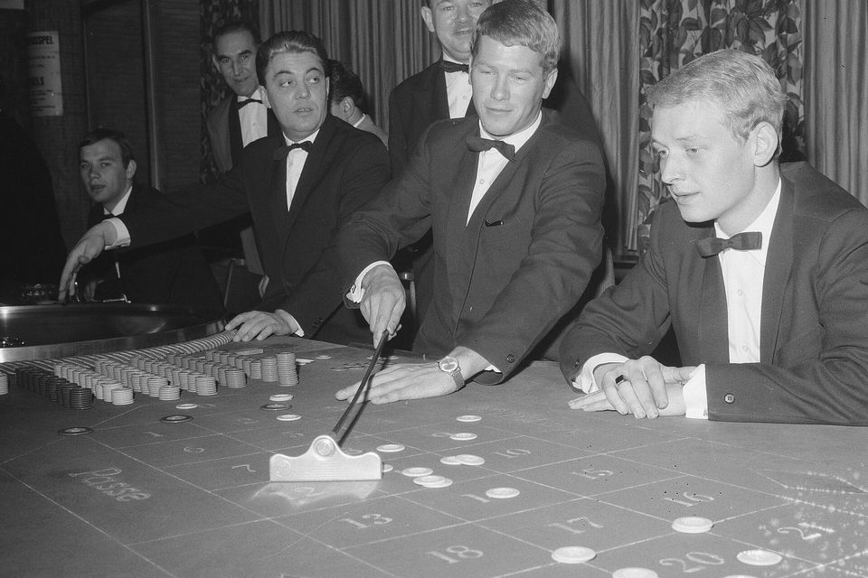 Croupiers a recolher as fichas numa mesa de roleta
